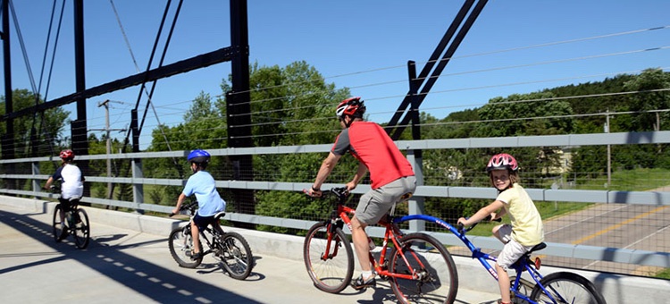 Four bike riders, with two on a tandem bike ride roll in Minnesota