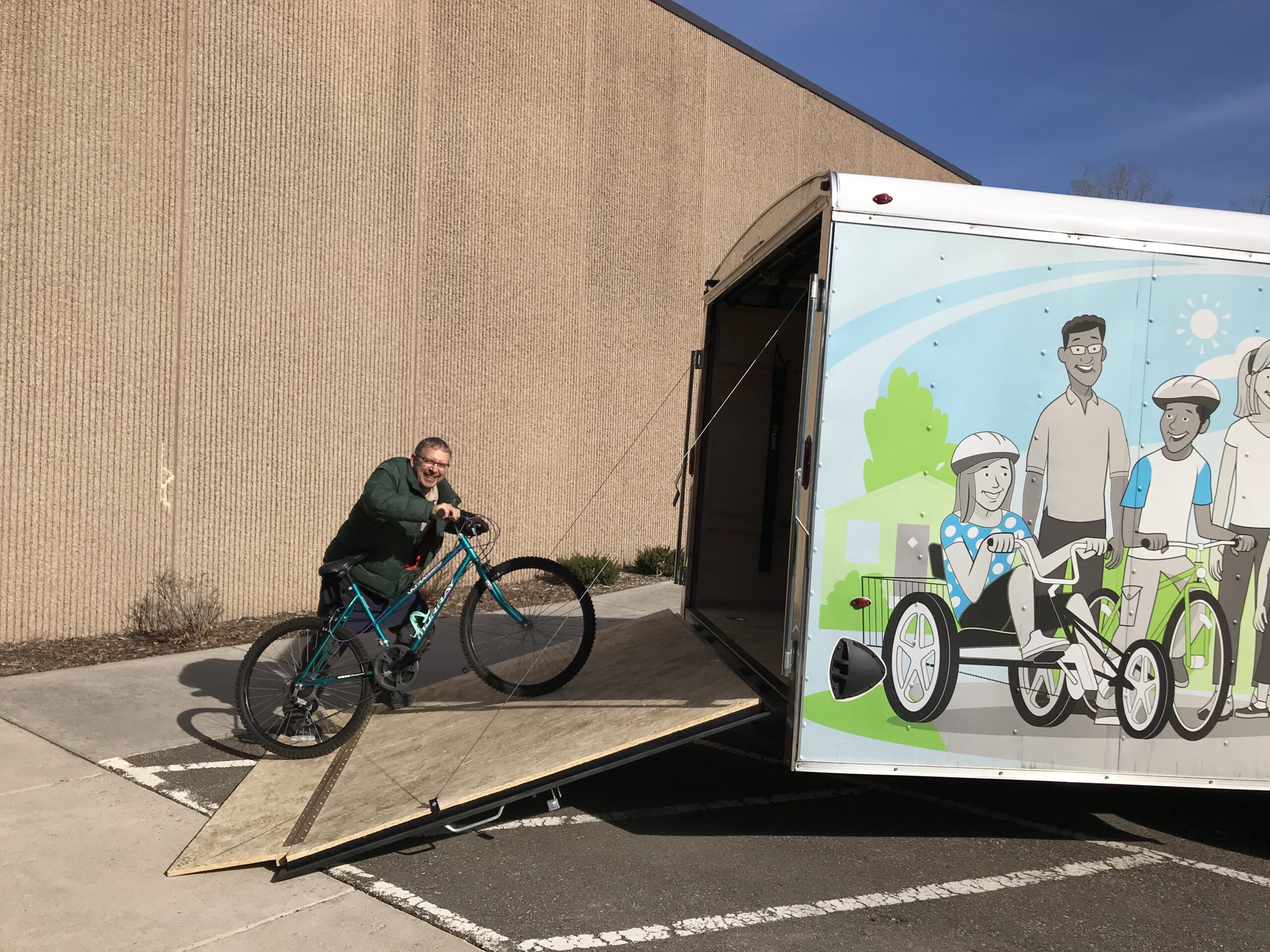 A bike is wheeled up a ramp to the BikeMN trailer