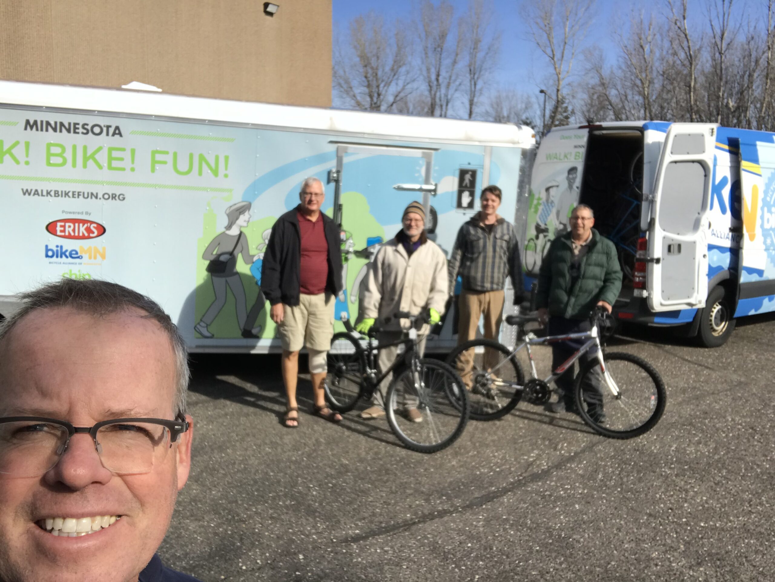Pete, Tim, and Lynn from the Recyclery help CJ and Dorian load bikes that were donated and repaired by the Recyclery.