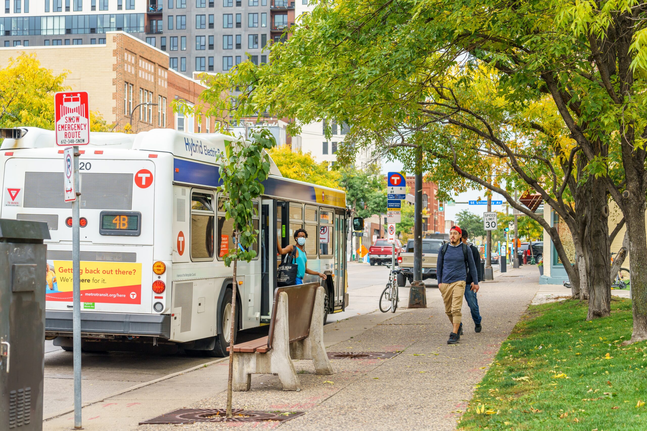 Metro Transit Forward image of city sidewalk and bus transit users
