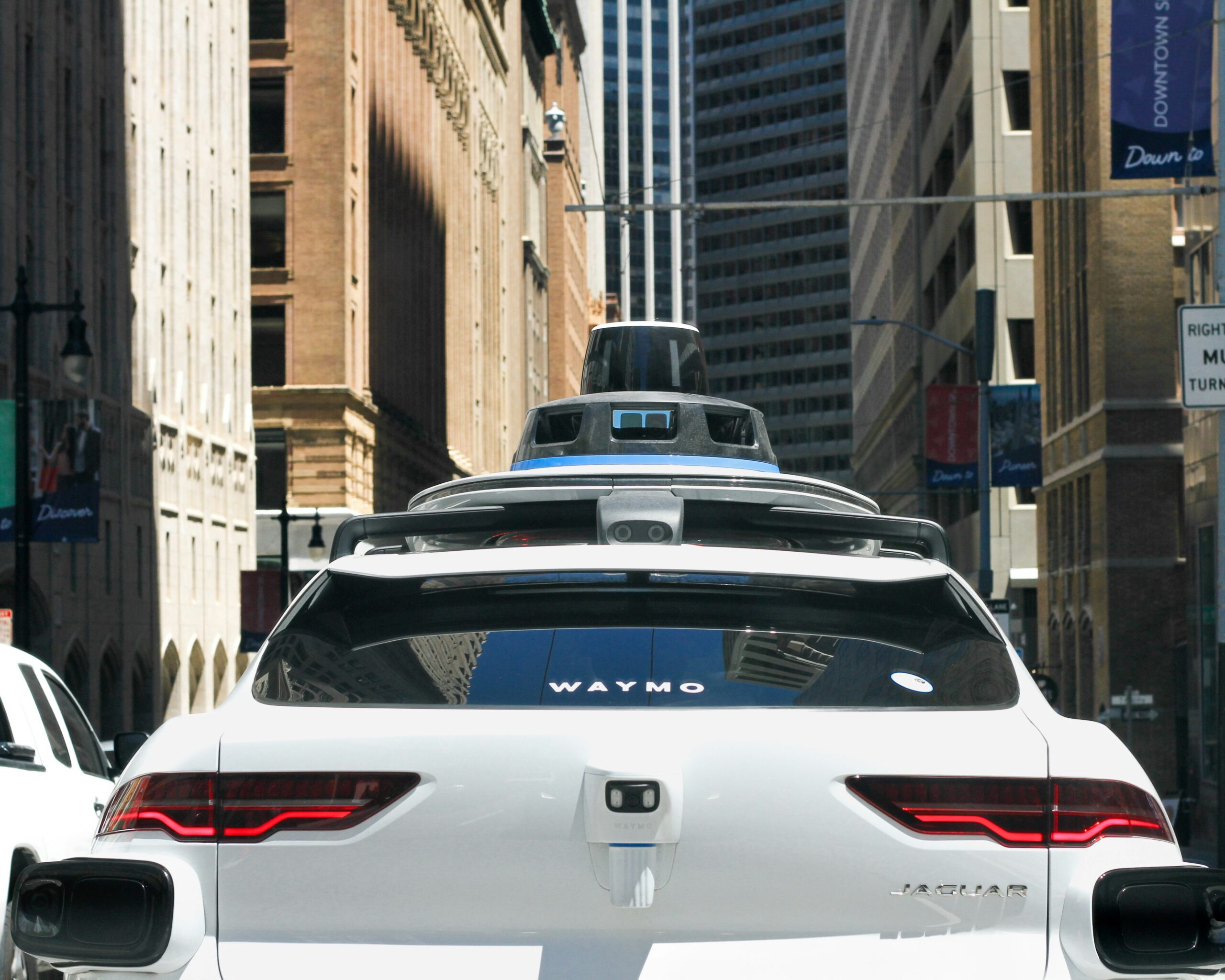 photo of a self driving vehicle from behind. it is in an urban context.