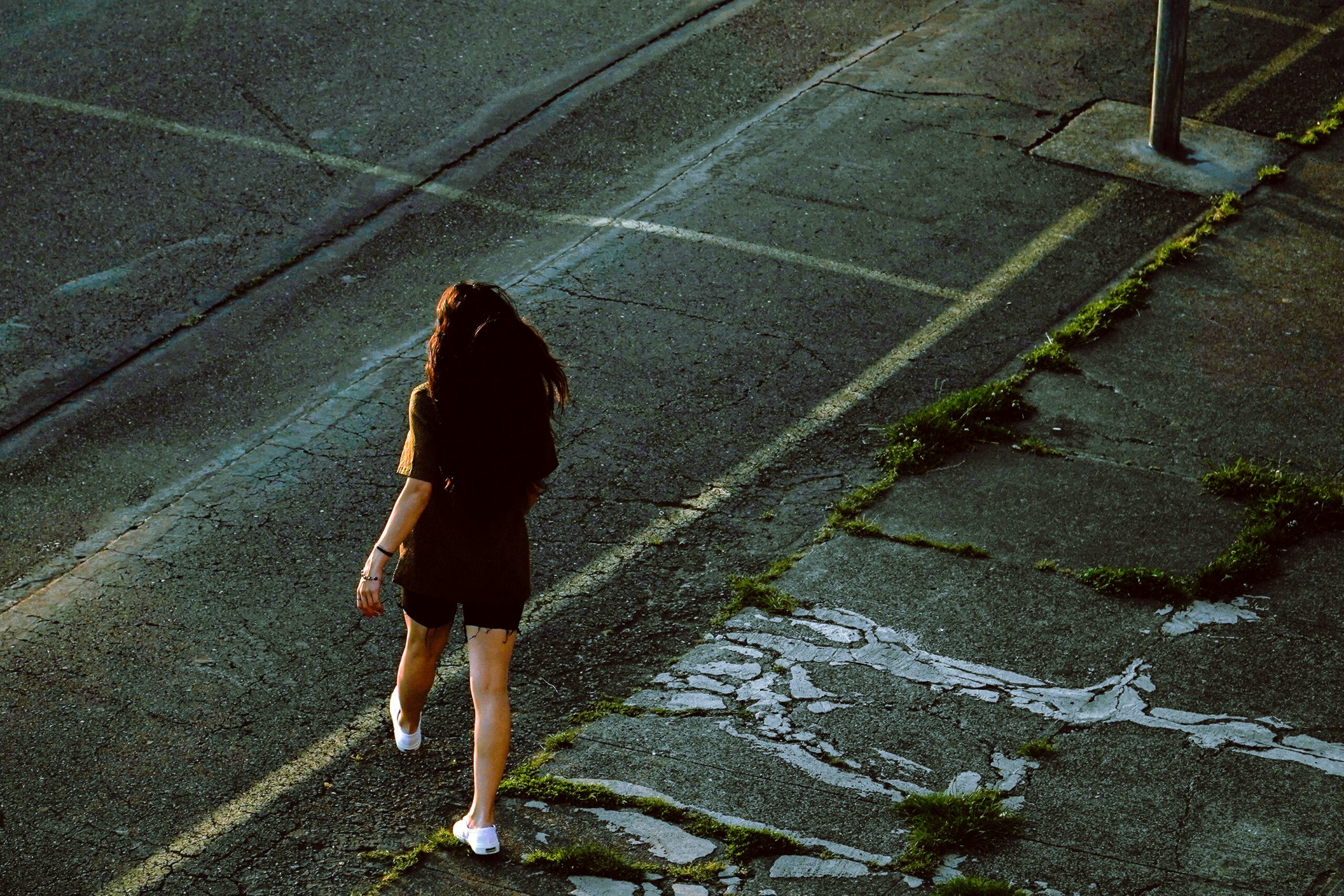 Woman crossing an empty street, mid-block